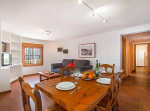 a dining room with a wooden table and a couch at Villa Alexia - Plusholidays in Calpe