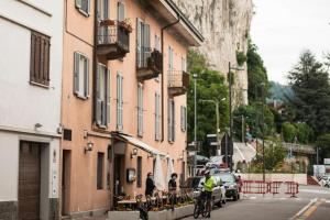 a man riding a bike down a street next to buildings at La Casolicchia di Arona in Arona