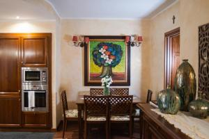 a kitchen with a table with chairs and a painting on the wall at La Casolicchia di Arona in Arona