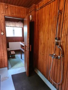 a bathroom with a shower in a wooden wall at Saltvik Bed & Breakfast in Saltvik