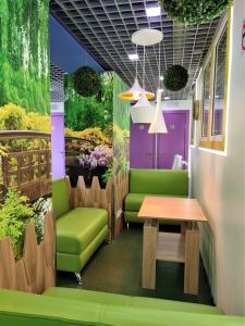 a waiting room with a green couch and a table at City Garden Hotel Taganskaya in Moscow