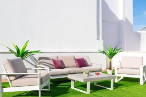 a patio with two chairs and a couch and a table at Genteel Home San Antonio in Cádiz