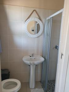 y baño con lavabo, aseo y espejo. en Marine48 Self-catering Port Elizabeth, en Port Elizabeth