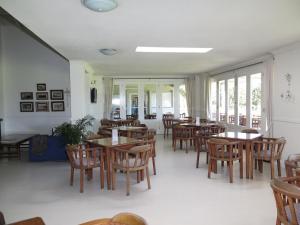 a restaurant with wooden tables and chairs and windows at Goose Valley Retreat with Sea Views in Plettenberg Bay
