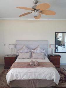 1 dormitorio con 1 cama grande y ventilador de techo en Marine48 Self-catering Port Elizabeth, en Port Elizabeth