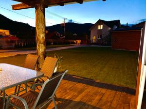 a patio with a table and chairs and a lawn at P&P APARTMÁNY Bojnice in Bojnice