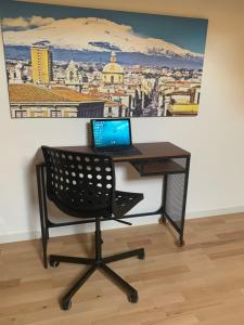 biurko z laptopem na górze w obiekcie Hygge House Catania w Katanii