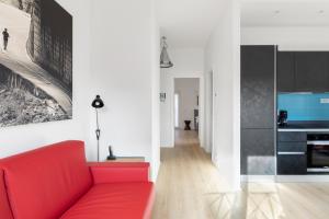 ein Wohnzimmer mit einem roten Sofa und einer Küche in der Unterkunft Roman Residenza in Rom