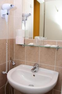 a bathroom with a sink and a mirror at Hotel Adalbert Szent György Ház in Esztergom