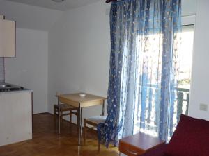 sala de estar con mesa y cortina azul en Guest House Potok en Lokve