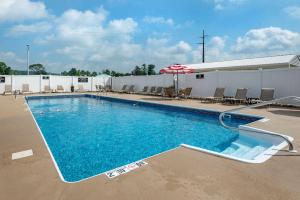 einen Pool mit Sonnenschirm und Stühlen in der Unterkunft Comfort Inn Lancaster County North in Denver