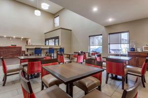 een restaurant met tafels, stoelen en ramen bij Comfort Suites in Memphis