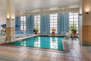 a pool in a hotel lobby with blue walls and windows at Comfort Inn Lafayette I-65 in Lafayette