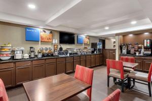 a restaurant with a table and chairs and a bar at Comfort Inn Lafayette I-65 in Lafayette