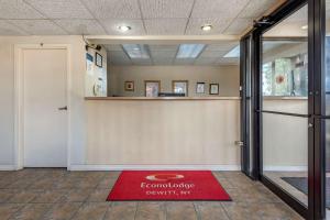 un vestíbulo con una alfombra roja de bienvenida en el suelo en Econo Lodge Dewitt I-90, en DeWitt