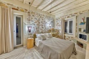 a bedroom with a bed and a stone wall at Marconi's seaside villa in Megas Gialos - Nites +39 photos