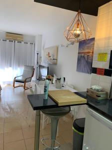 eine Küche mit einem Tisch und ein Wohnzimmer in der Unterkunft Luxury estudio Júpiter minerva in Benalmádena