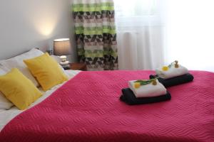 ein Schlafzimmer mit einem rosa Bett mit Handtüchern darauf in der Unterkunft Apartament Orange Sun nr°6 in Pobierowo