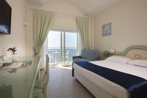 ein Schlafzimmer mit Bett und Balkon mit Meerblick in der Unterkunft Summit Hotel in Gaeta