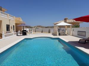 a swimming pool in front of a house at Los Torres Casa Lindsay in Arboleas