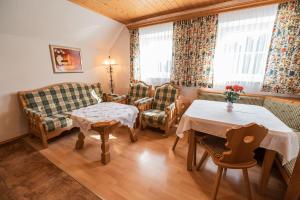 ein Wohnzimmer mit einem Sofa, einem Tisch und Stühlen in der Unterkunft Bio-Landhaus Kesslerhof in Gröbming