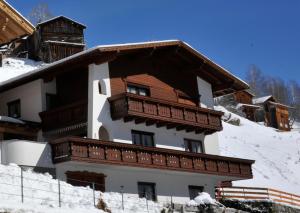 a building with a balcony on a snow covered slope at Apart Piz Palü Kappl/Ischgl in Kappl