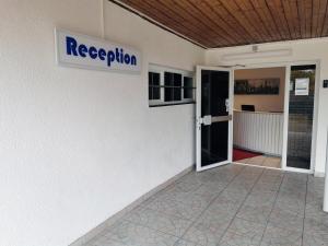 een bord aan de zijkant van een gebouw met de naam receptie bij Murgtal Motel in Rastatt