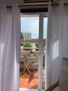 Zimmer mit Blick auf einen Balkon mit weißen Vorhängen in der Unterkunft Luxury estudio Júpiter minerva in Benalmádena