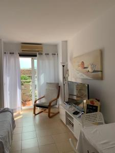 Zimmer mit einem Bett, einem TV und einem Stuhl in der Unterkunft Luxury estudio Júpiter minerva in Benalmádena