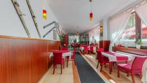 uma sala de jantar com cadeiras vermelhas e mesas num restaurante em Planinarski Centar Petehovac em Delnice