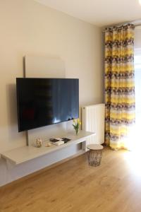 ein Wohnzimmer mit einem großen Flachbild-TV in der Unterkunft Apartament Orange Sun nr°6 in Pobierowo