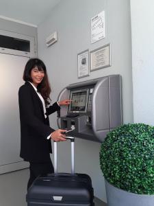 a woman standing in front of a cashier machine at mk | hotel münchen city in Munich