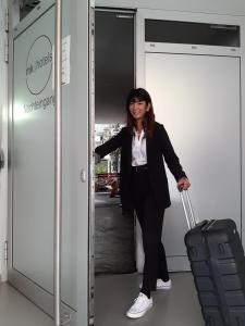 Eine Frau steht in einem Aufzug mit einem Koffer. in der Unterkunft mk | hotel münchen city in München