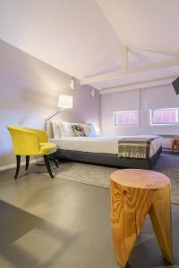 una camera da letto con un letto e una sedia gialla di Stay in Apartments Ribeira 24 a Porto