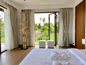 een slaapkamer met een bed en een groot raam bij Villa Tango Victoria Resort, Koh Yao Noi in Ko Yao Noi +51 foto's