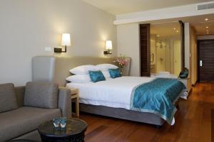 a hotel room with a bed and a couch at Chapmans Peak Beach Hotel in Hout Bay
