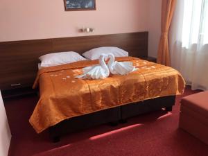 twee zwanen op een bed in een slaapkamer bij Hotel Jelen in Hlohovec