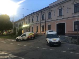 a car is parked in front of a building at Hotel Jelen in Hlohovec