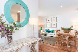 a living room with a table and a mirror at Genteel Home San Antonio in Cádiz