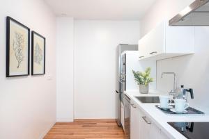 a kitchen with white cabinets and a sink at Genteel Home San Antonio in Cádiz