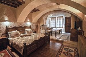 a bedroom with a large bed in a stone room at Melis Cave Hotel in Urgup