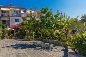 a house with a lot of plants in front of it at Dalmati house in Brodarica