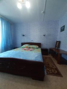 ブリャンスクにあるGostinitsa Turistのベッドルーム1室(青いシーツとテーブル付)