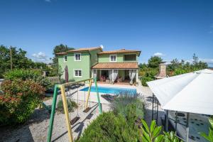 a villa with a swimming pool and a house at Spacious holiday house / pool / jacuzzi / playground / 6+2 in Rakalj