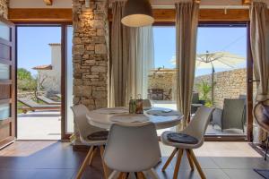 Un comedor con una mesa y sillas blancas. en Cozy villa Pietra with private pool and whirpool, en Šišan