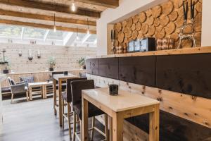 a restaurant with wooden tables and a bar at Hotel Chalet S - Dolomites Design - adults recommended in Selva di Val Gardena