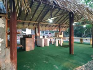 a pavilion with tables and a grass roof at Casa de Praia Ponta de Pedras in Alter do Chao