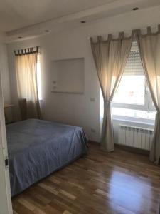 1 dormitorio con 1 cama y una ventana con cortinas en MADD HOUSE BIS, en Roma