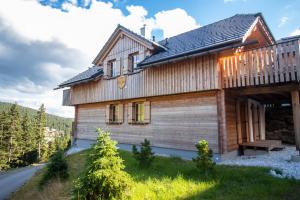 a wooden house with a deck on a mountain at Chalet Risus Vallis Lachtal in Lachtal