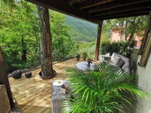 un patio con sofás y plantas en una terraza de madera en Bed & Breakfast SENTIERO 54, en Cantiano